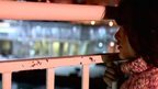 Migrant girl looks through railings