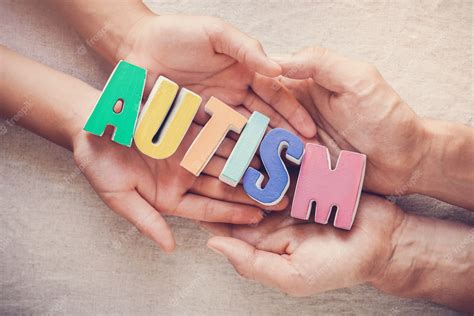 Premium Photo | Hands holding autism word, mental health concept, world ...