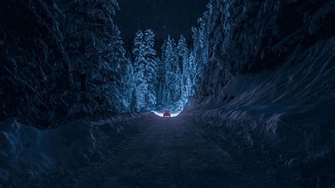 Download A Snowy Road With A Blue Light In The Middle | Wallpapers.com