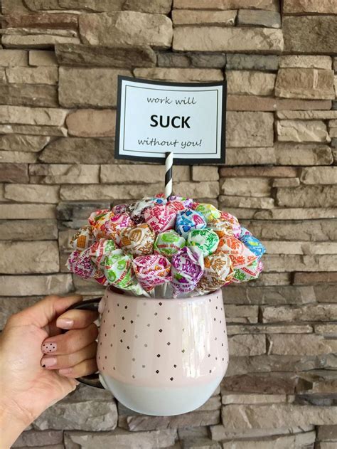 a person holding a cup filled with colorful candies in front of a brick ...