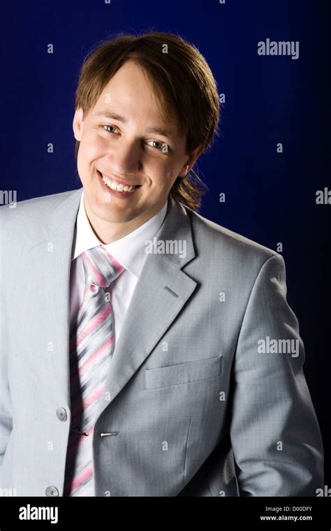 Young man wearing suit laughing over dark background Stock Photo - Alamy