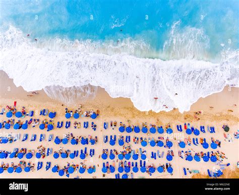 Bird's-eye view of a beach with big waves, sunbeds and umbrellas in ...