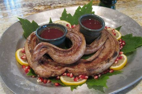 octopus tentacles with sauces and lemon wedges on a silver plate ...