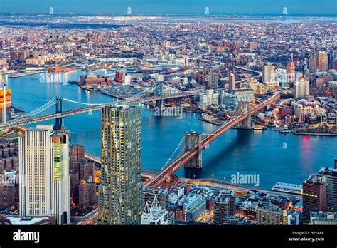 Brooklyn and Manhattan bridges span East River at dusk, between ...