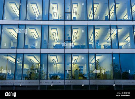 Facade of a modern office building with lights on in the offices in ...