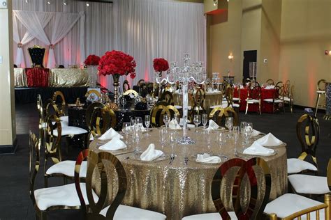 a banquet room set up with gold sequin tablecloths and red flowers in vases