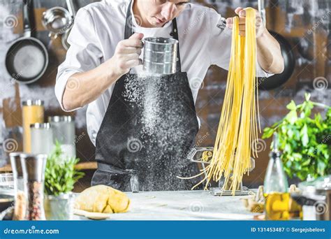 Chef Making Spaghetti Noodles with Pasta Machine on Kitchen Table with ...