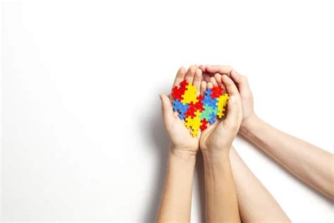 Child hand holding colorful heart on yellow background. World autism ...