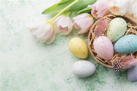 Bowl with Easter eggs painted pastel colors on a green wooden ...