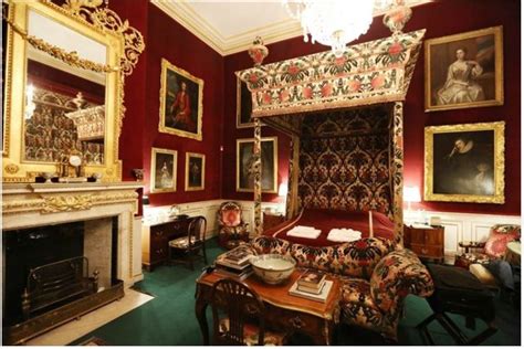 a bedroom with red walls and paintings on the wall, including a bed in ...