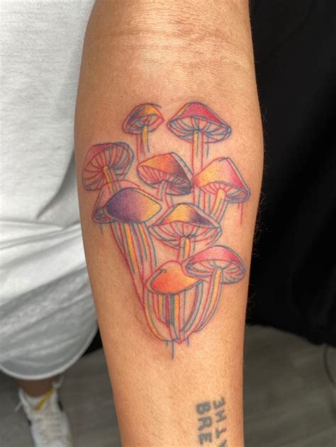 a person with a tattoo on their arm that has mushrooms in the middle of it