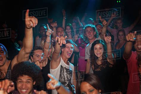 Enthusiastic crowd cheering at concert - Stock Photo - Dissolve