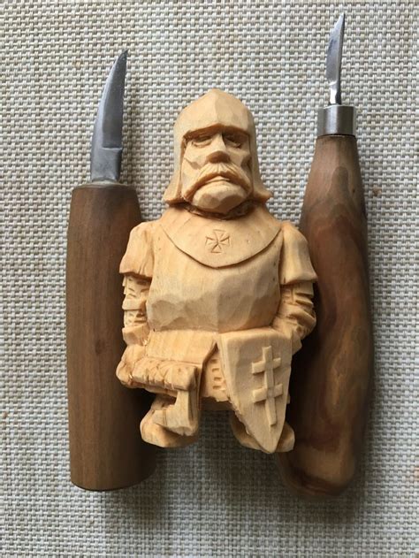 a wooden carving of a man with two knives and a knife holder on the wall