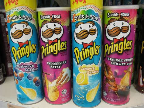 three cans of pringles are sitting on a shelf in a store, one is blue ...