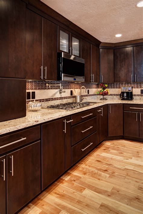 a kitchen with wooden floors and brown cabinets