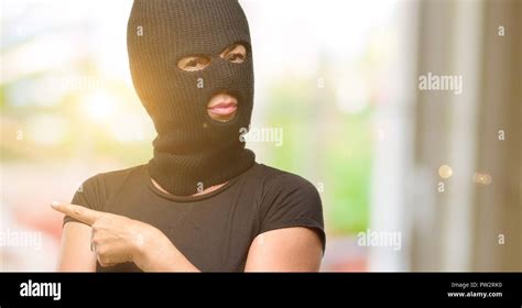 Burglar terrorist woman wearing balaclava ski mask pointing away side ...