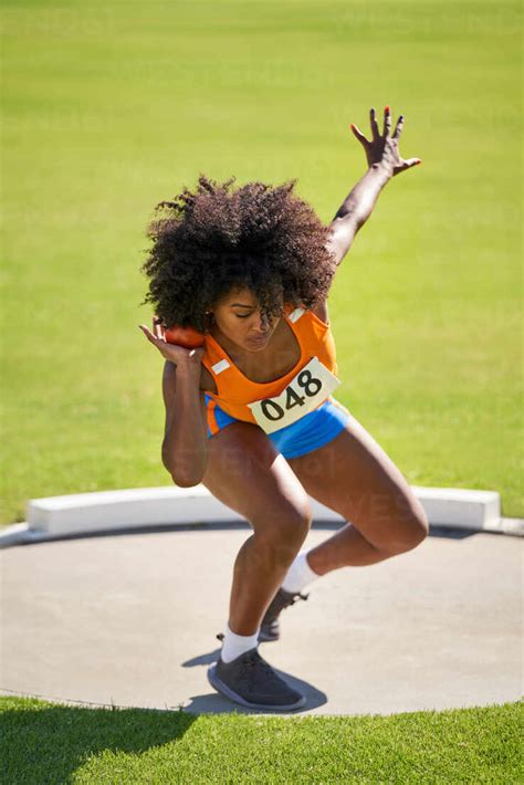 Female track and field athlete throwing shot put stock photo