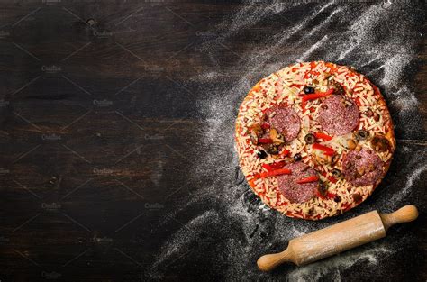 Pizza, rolling pin, flour on dark black background, copy space, top ...