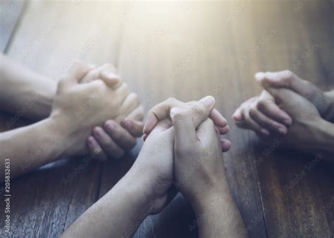 Christian bother and sister and praying together around wooden table ...