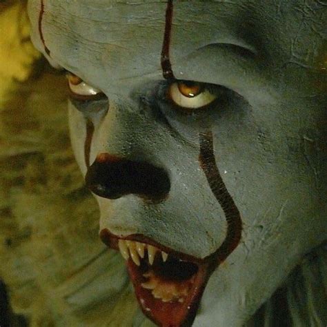 a creepy clown with yellow eyes and teeth