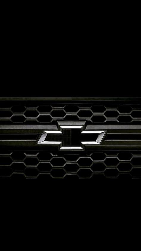 the front grille of a black chevrolet truck in the dark with honeycomb ...