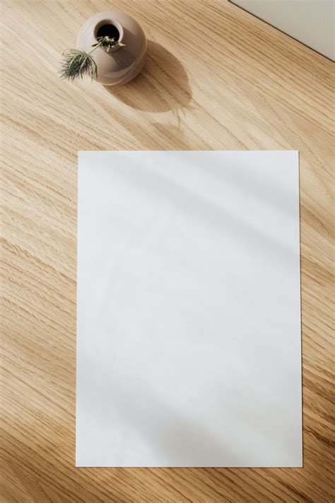 Blank white paper sheet on wooden table · Free Stock Photo