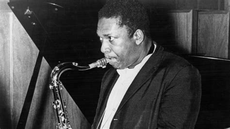 a man playing a saxophone in front of a piano