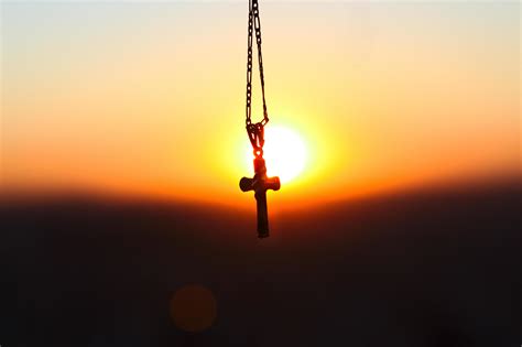 Cross pendant silhouette in front of sunset 1231085 Stock Photo at Vecteezy