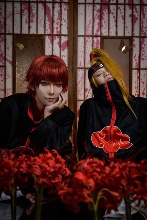 two people sitting next to each other with red flowers in front of them ...