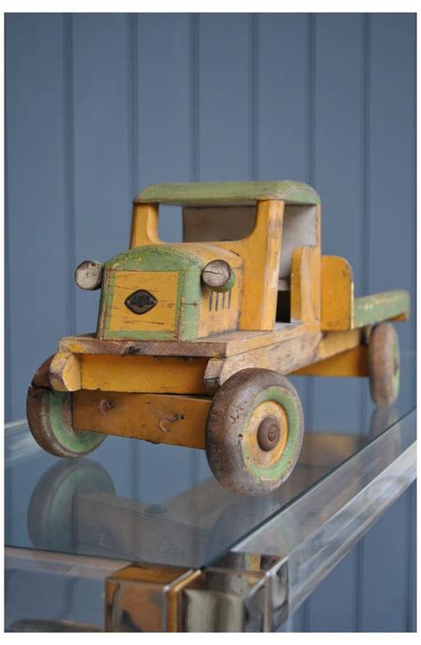 a wooden toy truck sitting on top of a glass shelf next to a blue wall