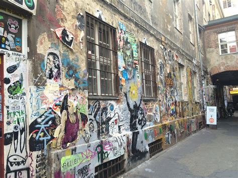 an alleyway with graffiti on the walls and windows, along with other ...