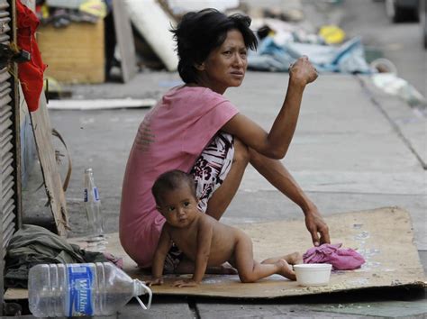 Homeless mother, with one of her children in Manila, Philippines. This ...