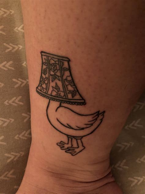 a hen with a lamp on it's leg is shown in this tattoo design