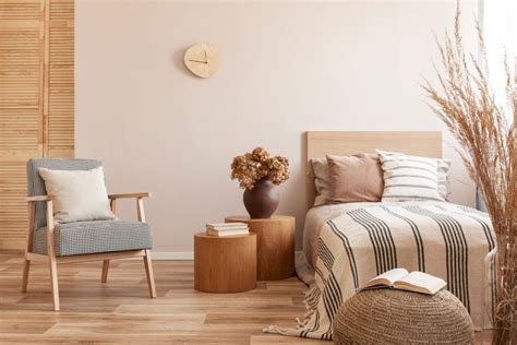 Beige room with wooden floors, wooden headboard, and stylish armchair ...