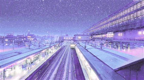 a train station at night with snow falling on the ground and buildings ...