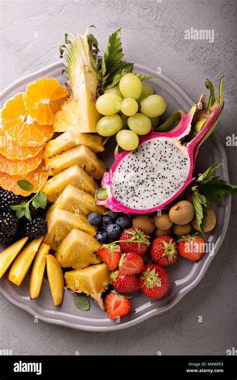 Exotic fruits platter with grapes, dragon fruit, longan and pineapple ...