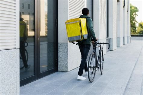 Premium Photo | The courier is walking with a big yellow backpack next ...