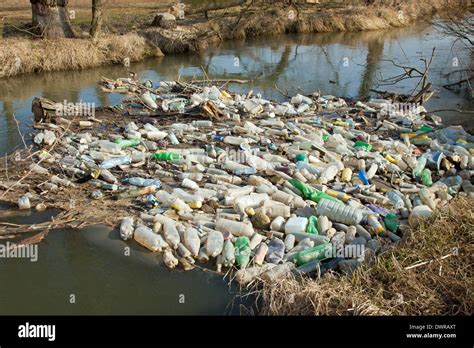 Environmental pollution. Plastic, glass and metal waste in river on ...