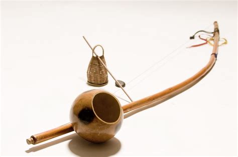 a wooden bow and arrow on a white surface with an object in the middle ...