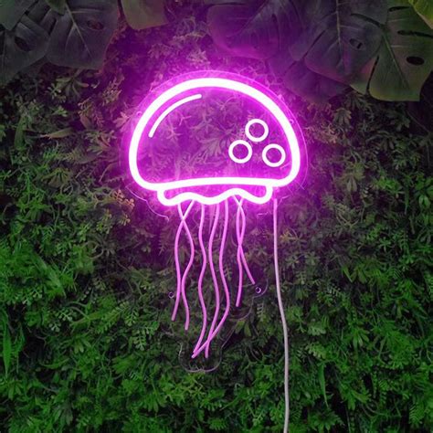 a neon purple jellyfish in the middle of some green plants and leaves ...