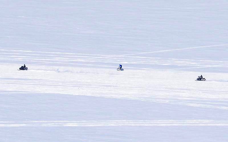 Snow mobiles and bicycle on the ice bridge