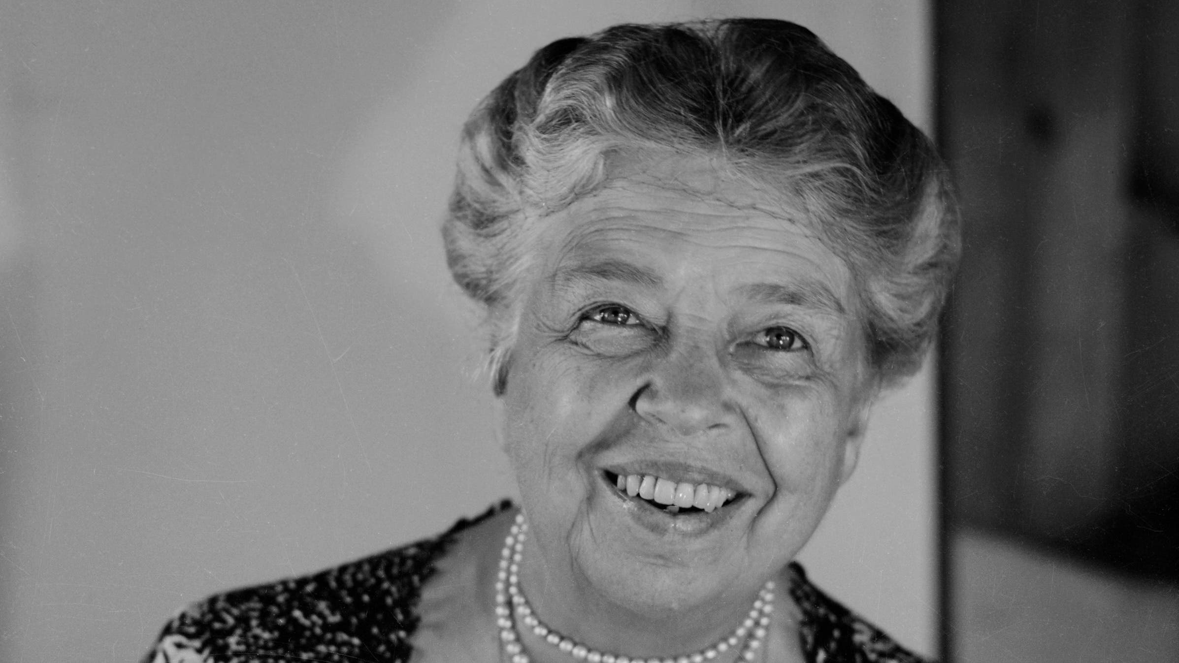 Eleanor Delano Roosevelt, seated, with a wide, warm smile