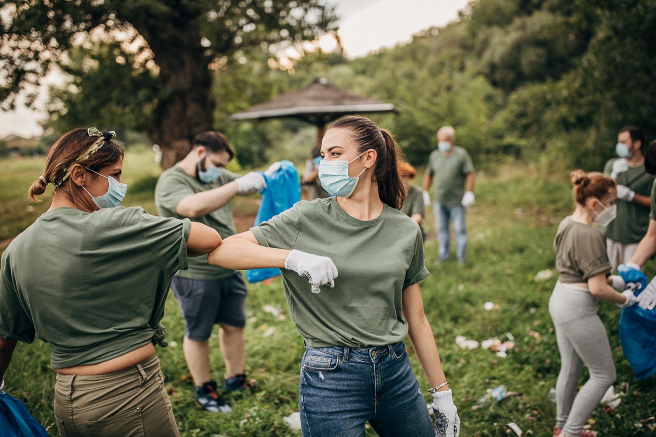 Two people smile at each other as they work outside