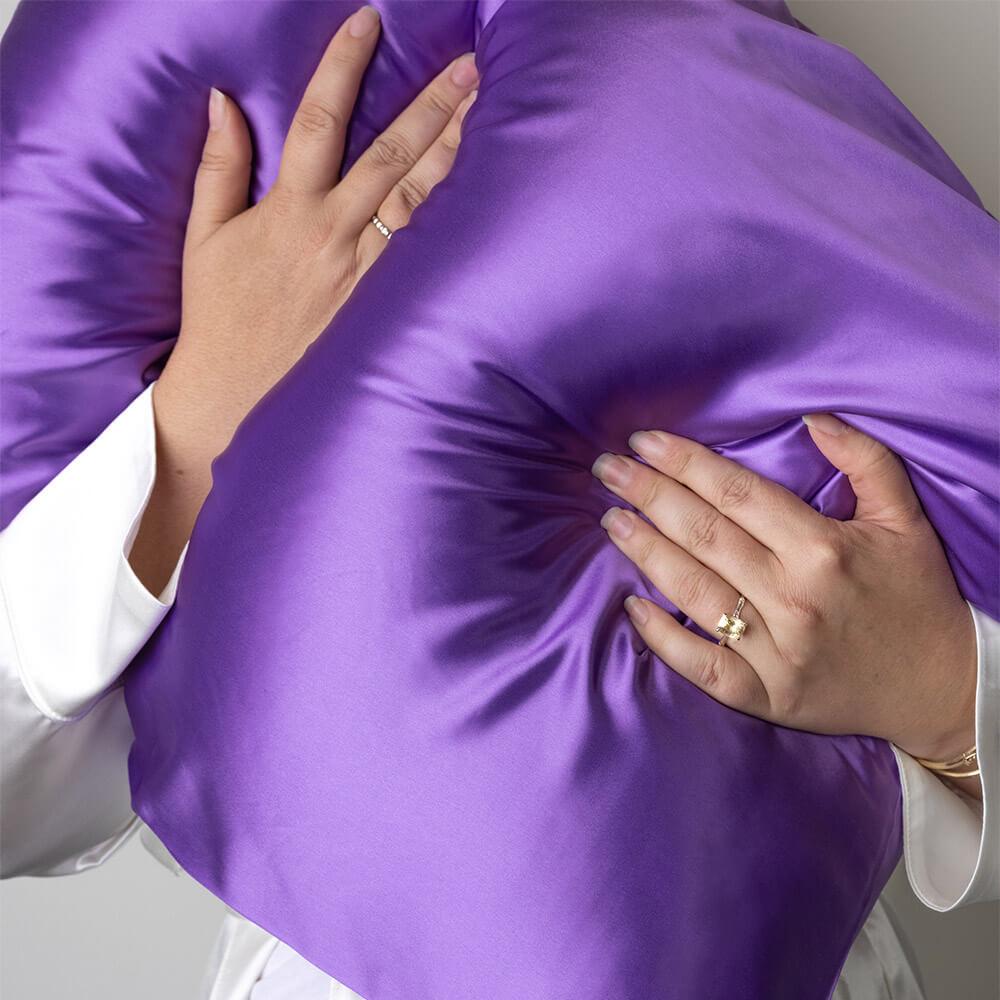 Hands holding an orchid Blissy mulberry silk pillowcase