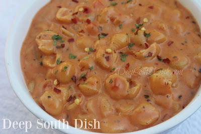 Tiny pasta shells cooked in a nicely seasoned tomato soup and milk-based sauce and finished with shredded cheese.