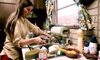 1280px-HOUSEWIFE_IN_THE_KITCHEN_OF_HER_M