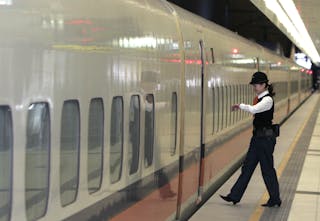 台灣高鐵＿An attendant enters a train at the Banqiao station in Taipei