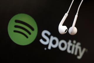 Headphones are seen in front of a logo of online music streaming service Spotify in this illustration picture