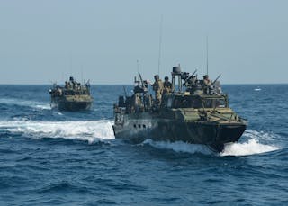 U.S. Navy handout photo of a riverine patrol boat from Costal Riverine Squadron 2 escorts the guided-missile cruiser USS Bunker 