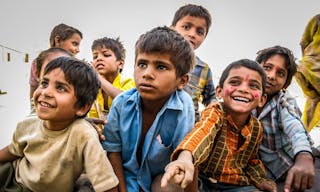 Jaisalmer, Rajasthan, India - March 27, 2008: Happy Indian children sitting out and laughing at desert village in Jaisalmer, Raj